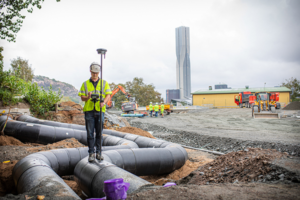Man med mätutrustning på byggarbetsplats